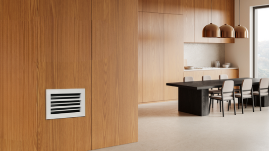 Aesthetic integration: White GREEN VENT grille on natural wood paneling in a modern kitchen/dining space