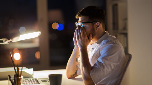 Man feeling tired and stressed while working late at his desk