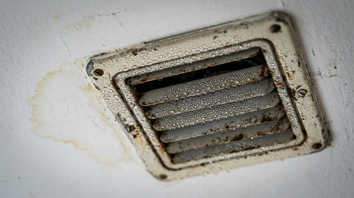 Condensation droplets on an old steel ceiling supply register